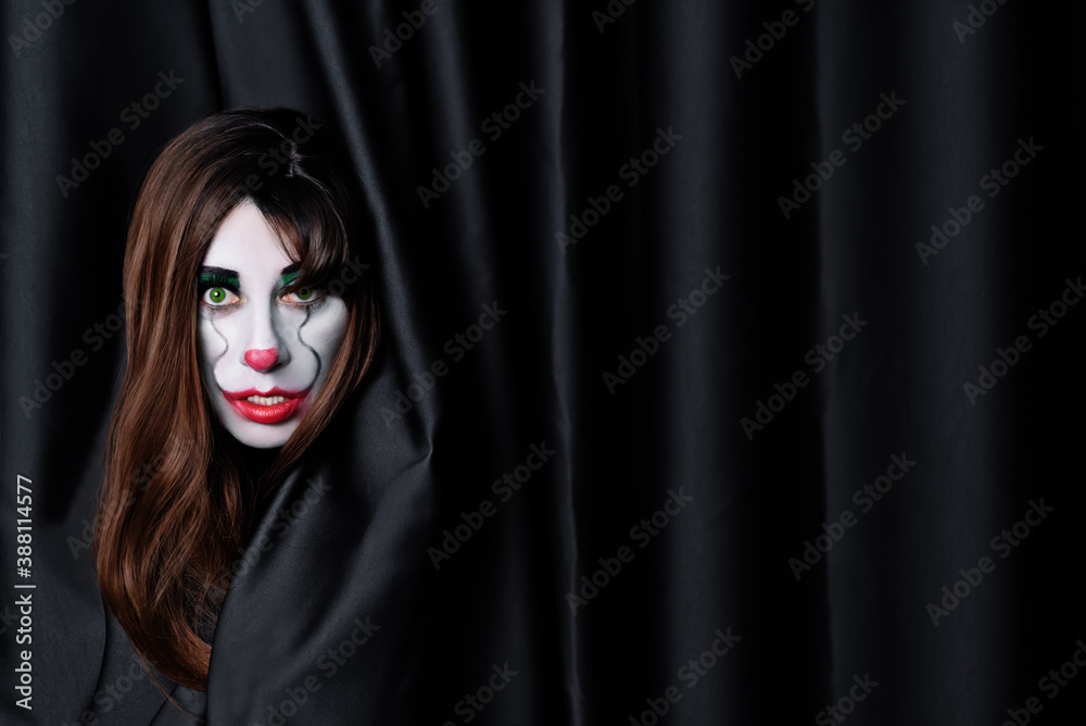 Brown haired woman clown with green eyes on a black background for Halloween Brown haired woman clown with green eyes on a black background for Halloween