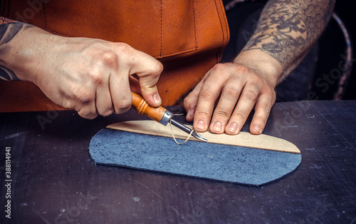 Artisan performing leatherwork on a new product piece photo