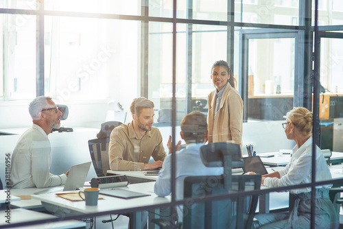 Project team at work. Group of multiracial business people sitting in board room in the modern office and discussing something while having a meeting