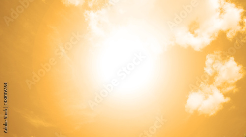 The bright sun shines against the background of an orange sky with white clouds. Background, texture © YAROSLOVEPHOTOVIDEO