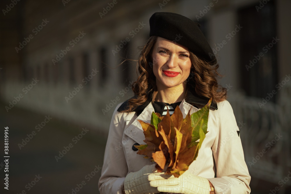 Portrait of happy elegant woman in beige trench coat