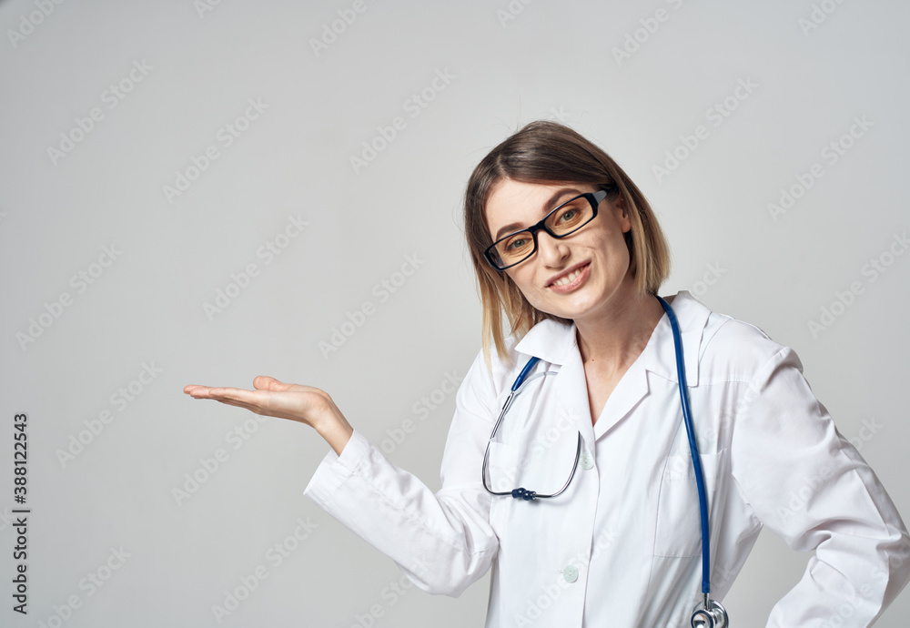 woman nurse in a medical gown gesturing with her hands on a light background copy space woman nurse in a medical gown gesturing with her hands on a light background copy space