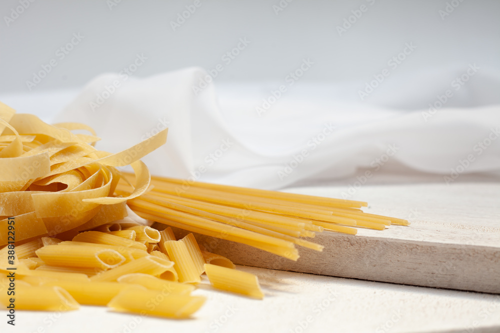Variety of pasta pasta on top of wood and white fine fabric. Variety of pasta pasta on top of wood and white fine fabric.