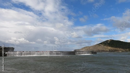 Waves crashing and splashing foam against the port breakwater