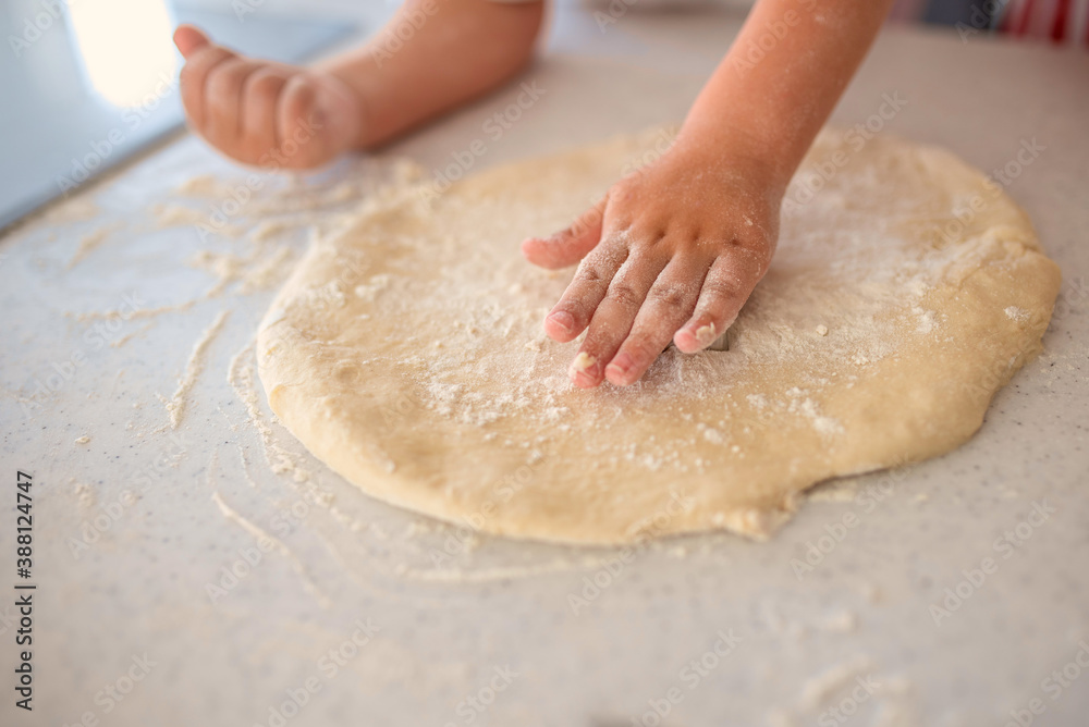 Close up of child playing with dough while preparing traditional Christmas cookies Close up of child playing with dough while preparing traditional Christmas cookies