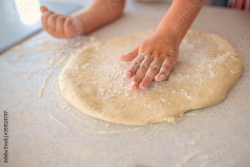Close up of child playing with dough while preparing traditional Christmas cookies 