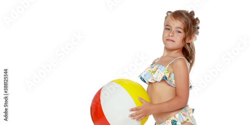 Little girl in a swimsuit with a ball. Children's emotions concept.