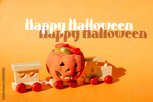 Happy Halloween card Jack o Lantern pumpkin halloween candy sweets bowl on ogange background. hard light image photo