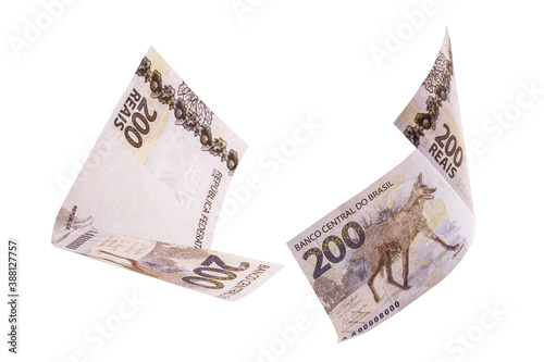 200 reais banknotes, bank notes falling on isolated white background. Two hundred reais from brazil, selective focus. Fall, inflation and loss concept photo