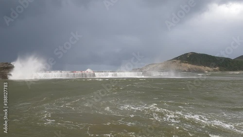 Waves crashing and splashing foam against the port breakwater