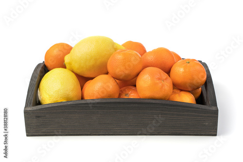 Fresh tangerines and lemons in a wooden box, top view. Isolated on a white background. The concept of natural products.