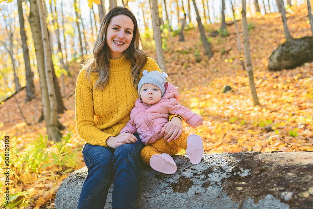 Baby daughter and her mother in the autumn season in park Baby daughter and her mother in the autumn season in park