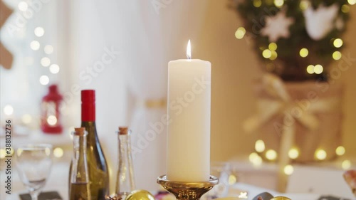 Close-up of candle on table set for dinner meal at Christmas time. photo