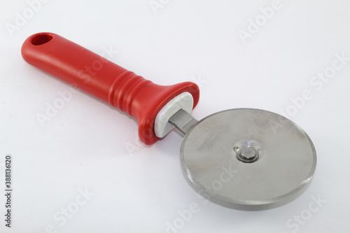 Circular pizza cutter with red handle and white background