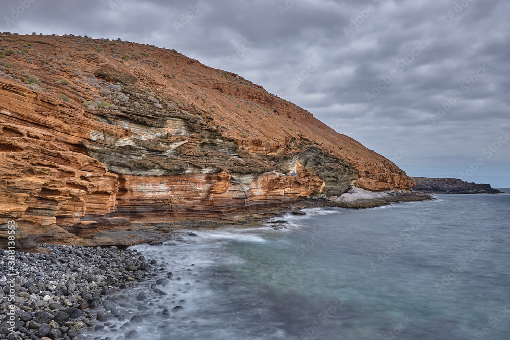 Long exposure of red cliffs close to el Medano, Tenerife. Red cliffs along the coastline of Tenerife, Canary Islands.