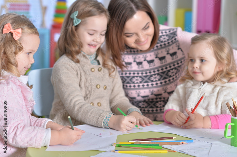 Mother and her three daughters drawing together Mother and her three daughters drawing together