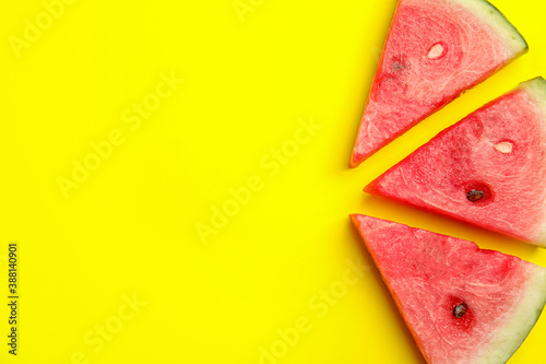 Slices of ripe watermelon on yellow background, flat lay. Space for text