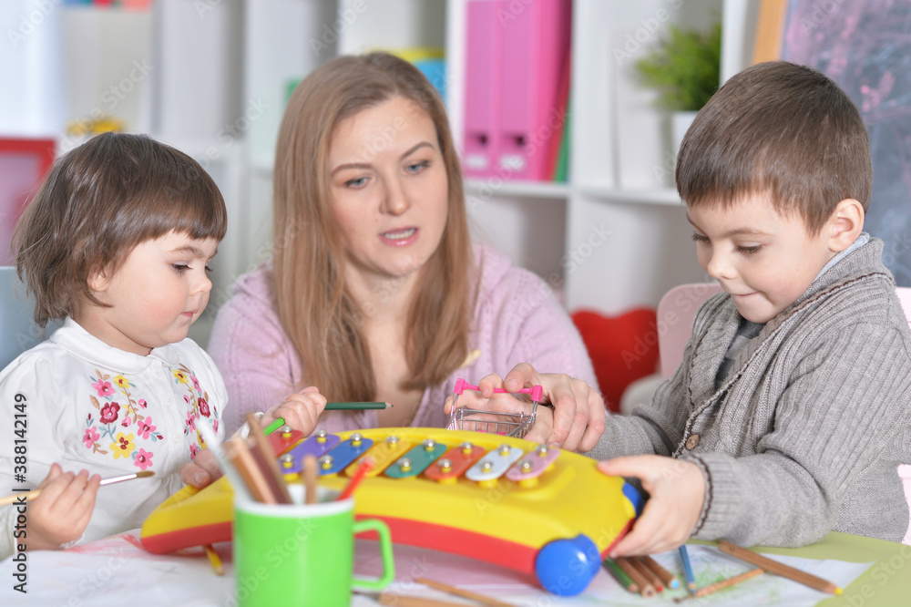 Mother with children playing together at home Mother with children playing together at home