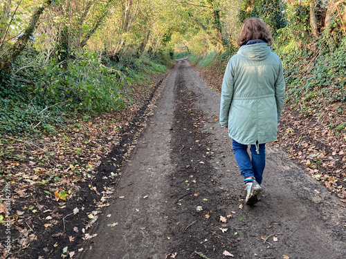 Fotografia Woman walking down an ancient holloway or drovers track on a bright and sunny au