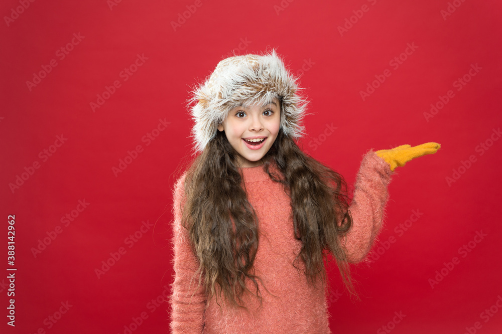 surprised kid wearing comfortable warm clothes for cold weather forecast on winter xmas holiday and vacation presenting product, surprise