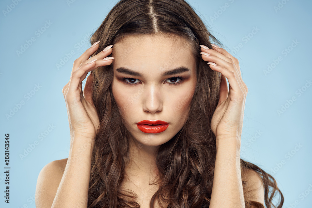 Brunette naked shoulders red lips fashionable hairstyle blue background Brunette naked shoulders red lips fashionable hairstyle blue background