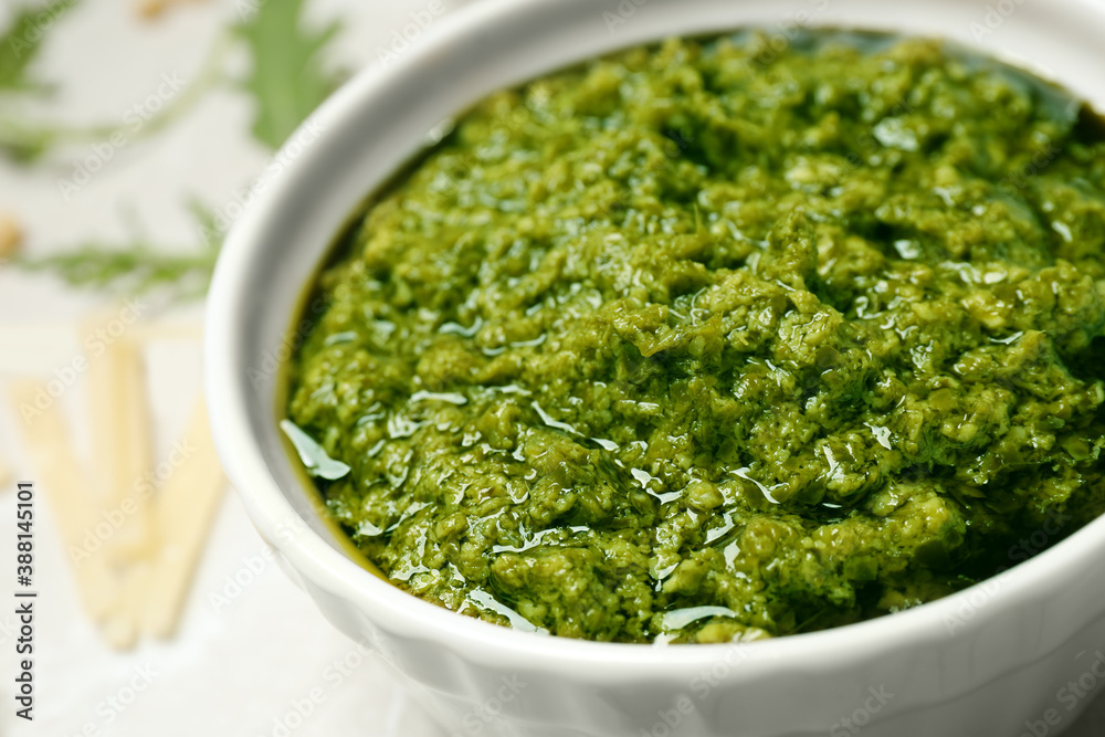 Bowl of tasty arugula pesto on table, closeup Bowl of tasty arugula pesto on table, closeup