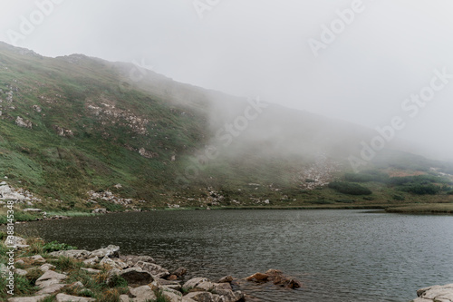 Mountain lake and in foggy day. Fog in Karpathian mountains. Tourism in Ukraine. Freedom and unity with nature