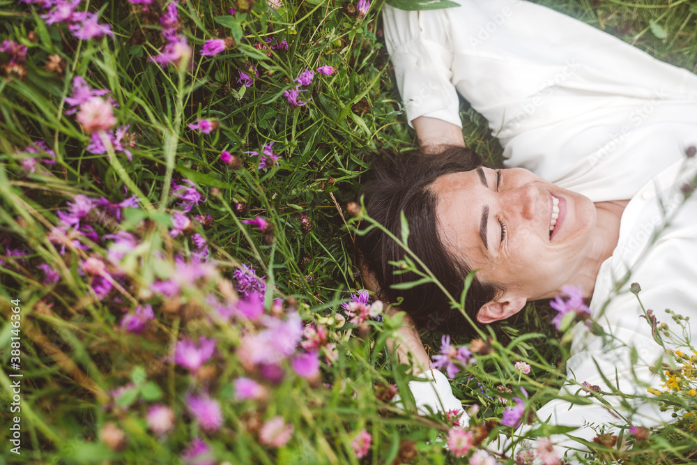 © Ekaterina Yakunina/Westend61 - Cheerful woman with eyes closed lying amidst plants on land © Ekaterina Yakunina/Westend61 - Cheerful woman with eyes closed lying amidst plants on land