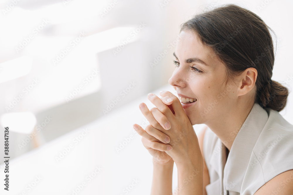 Thoughtful businesswoman with hand on chin sitting at office Thoughtful businesswoman with hand on chin sitting at office