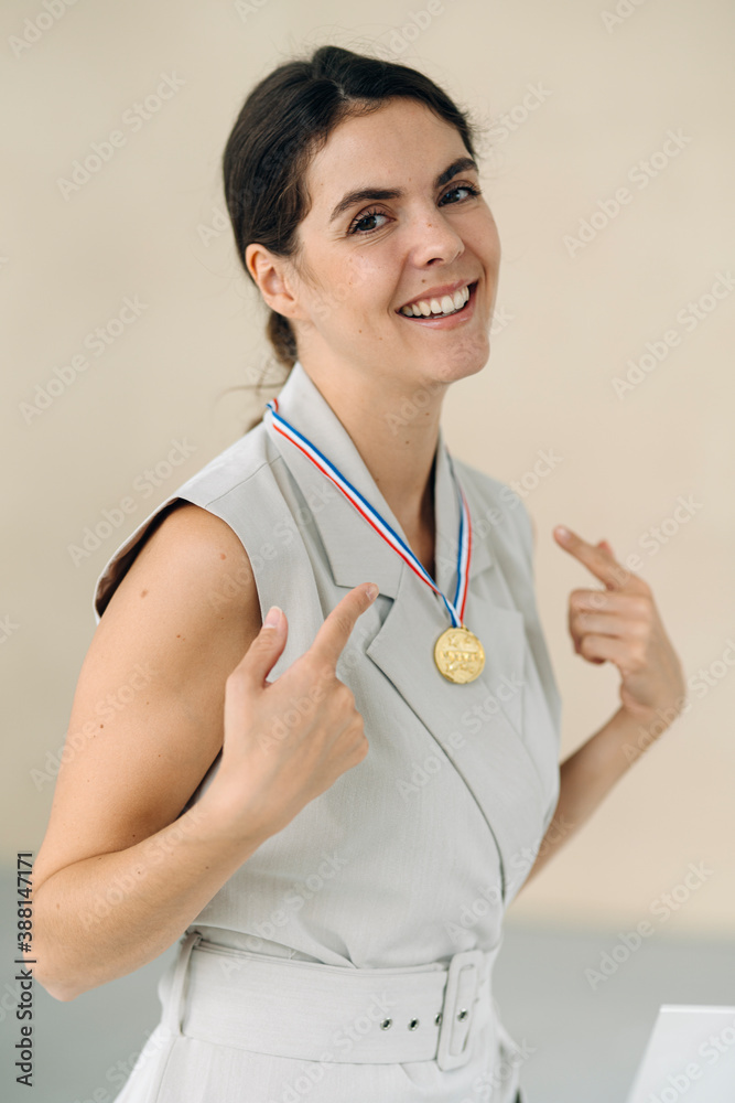 Businesswoman showing medal while standing at office Businesswoman showing medal while standing at office
