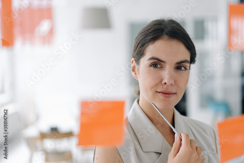 Businesswoman brainstorming while standing at office photo