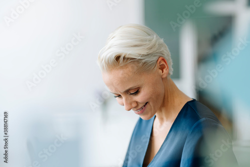 Close-up of smiling businesswoman looking down in office