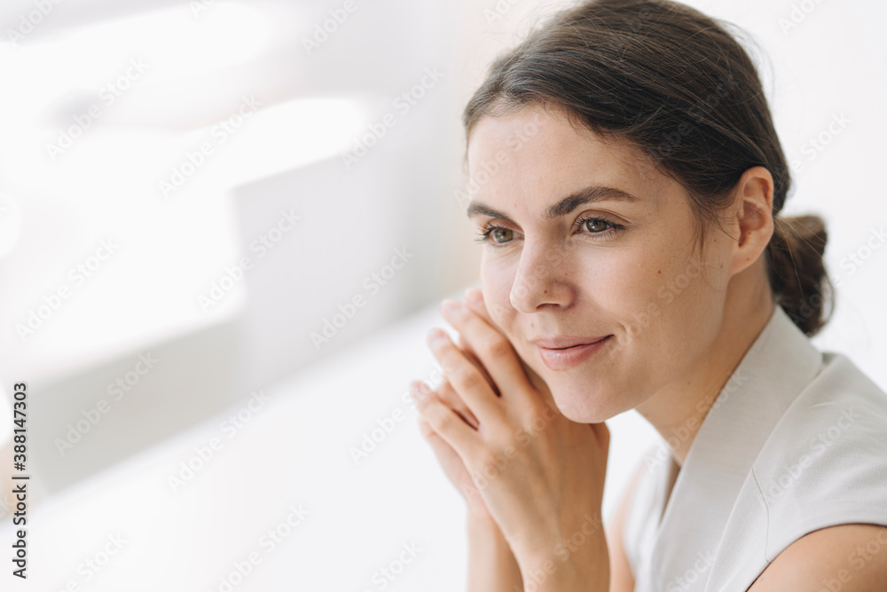 Beautiful woman with hand on chin sitting at office Beautiful woman with hand on chin sitting at office