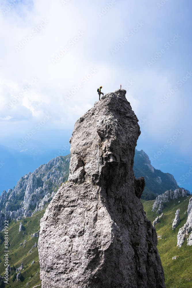 Male hiker standing on top of mountain against sky, European Alps, Lecco, Italy Male hiker standing on top of mountain against sky, European Alps, Lecco, Italy