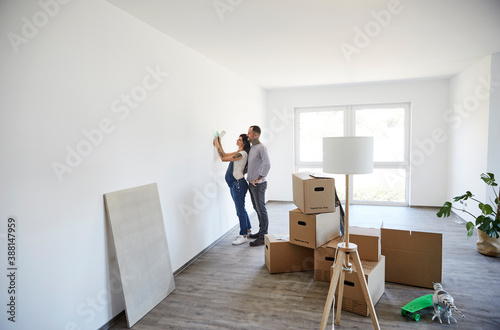 Couple trying light fixture on wall at new home
