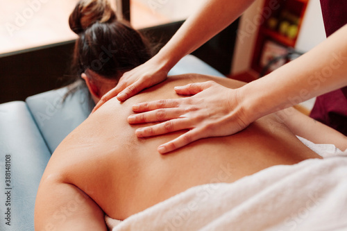 Woman having back massage while lying on stretcher photo