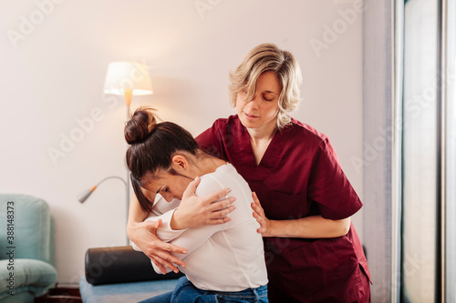 Physiotherapist treating patient's backache photo