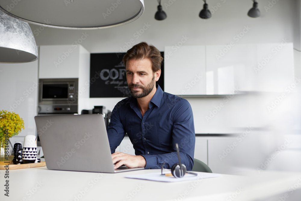 Man working on laptop while sitting at cafeteria Man working on laptop while sitting at cafeteria