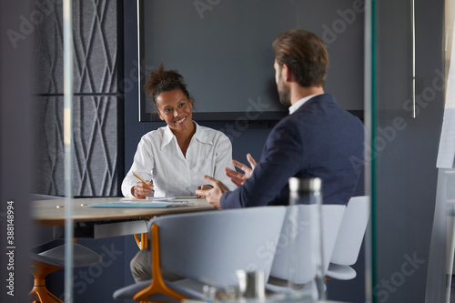 Businessman and colleague discussing while sitting in office