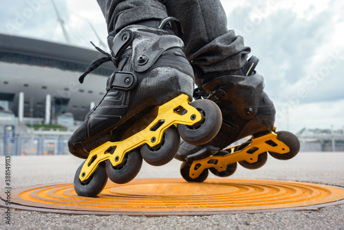 Legs of young man inline skating on manhole photo