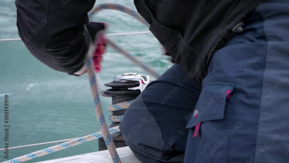 Sailor Pulling And Rolling Rope On The Boat Winch - close up Sailor Pulling And Rolling Rope On The Boat Winch - close up
