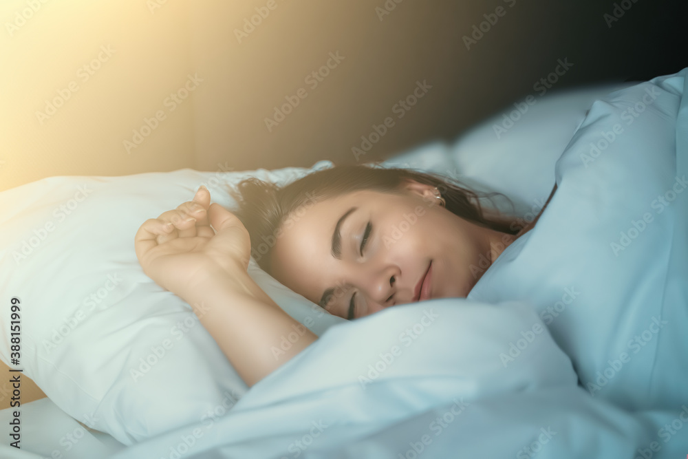 Beautiful young girl or woman sleeping sweetly in bed in early morning in rays of dawn, close up portrait. Beautiful young girl or woman sleeping sweetly in bed in early morning in rays of dawn, close up portrait.