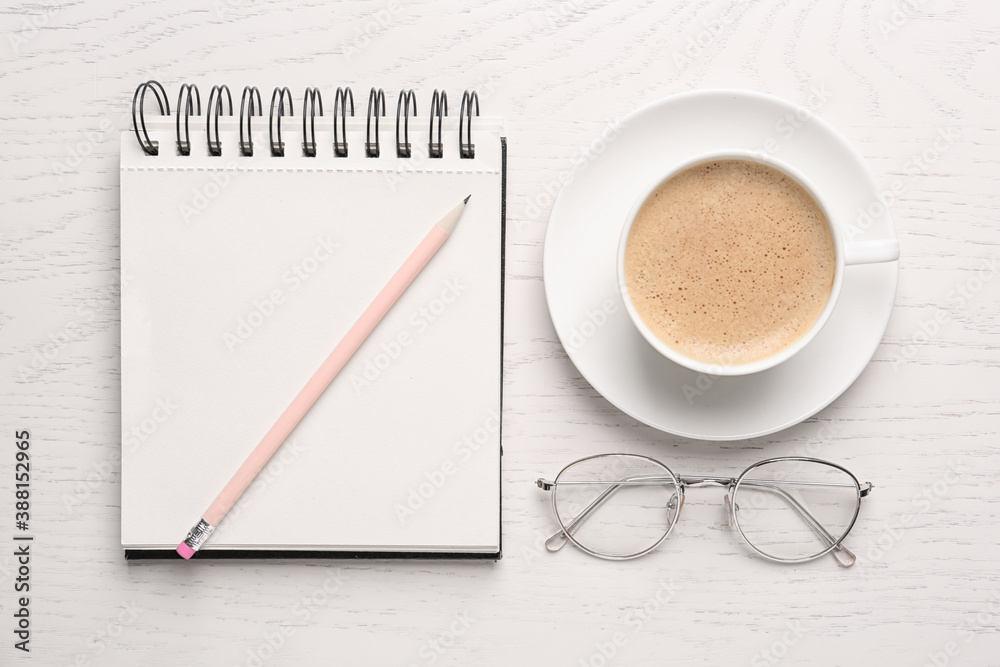 Notebook with pencil, glasses and cup of coffee on white wooden table, flat lay Notebook with pencil, glasses and cup of coffee on white wooden table, flat lay
