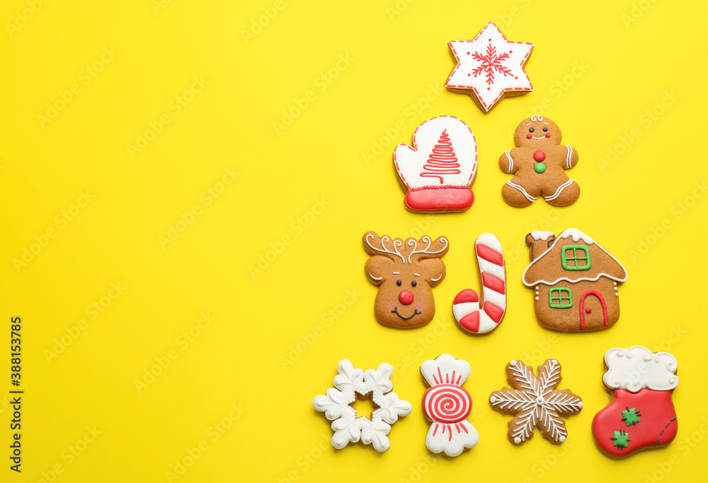 Delicious gingerbread cookies arranged in shape of Christmas tree on yellow background, flat lay. Space for text