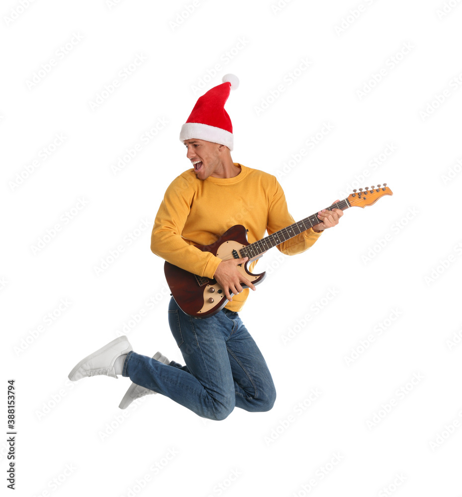 Man in Santa hat jumping with electric guitar on white background. Christmas music Man in Santa hat jumping with electric guitar on white background. Christmas music
