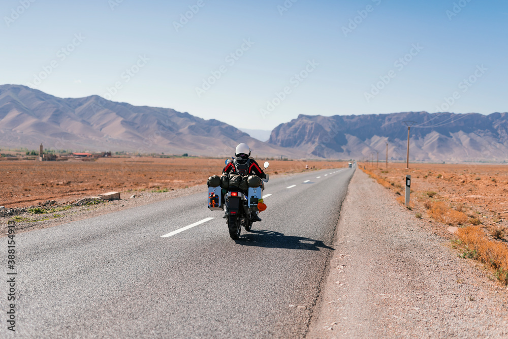 Biker riding an adventure motorcycle in Morocco desert Biker riding an adventure motorcycle in Morocco desert