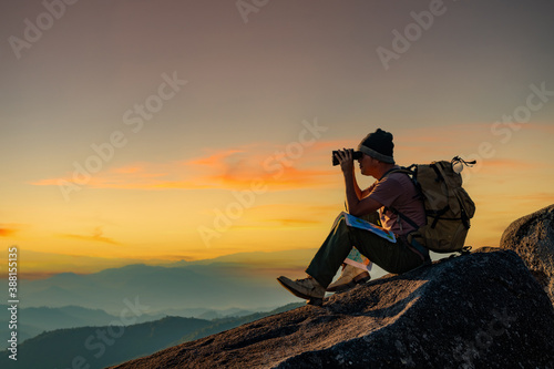 The hat binoculars are placed on the map in the beautiful landscape of the mountains.