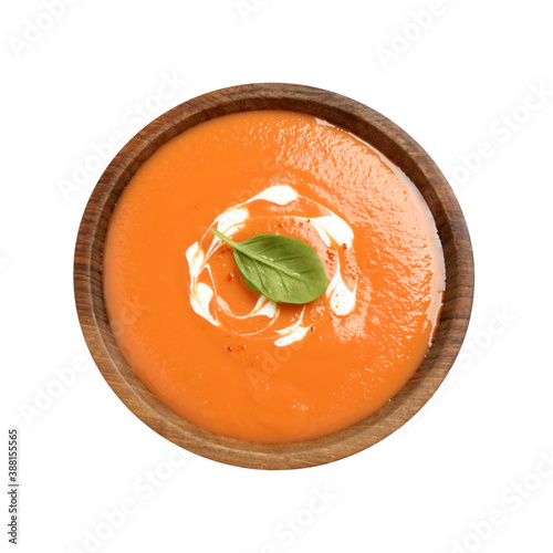 Tasty creamy pumpkin soup with basil in bowl on white background, top view