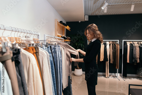 Woman choosing clothes in fashion store photo