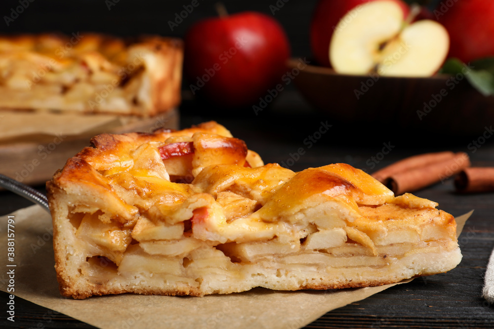 Slice of traditional apple pie on black wooden table, closeup Slice of traditional apple pie on black wooden table, closeup
